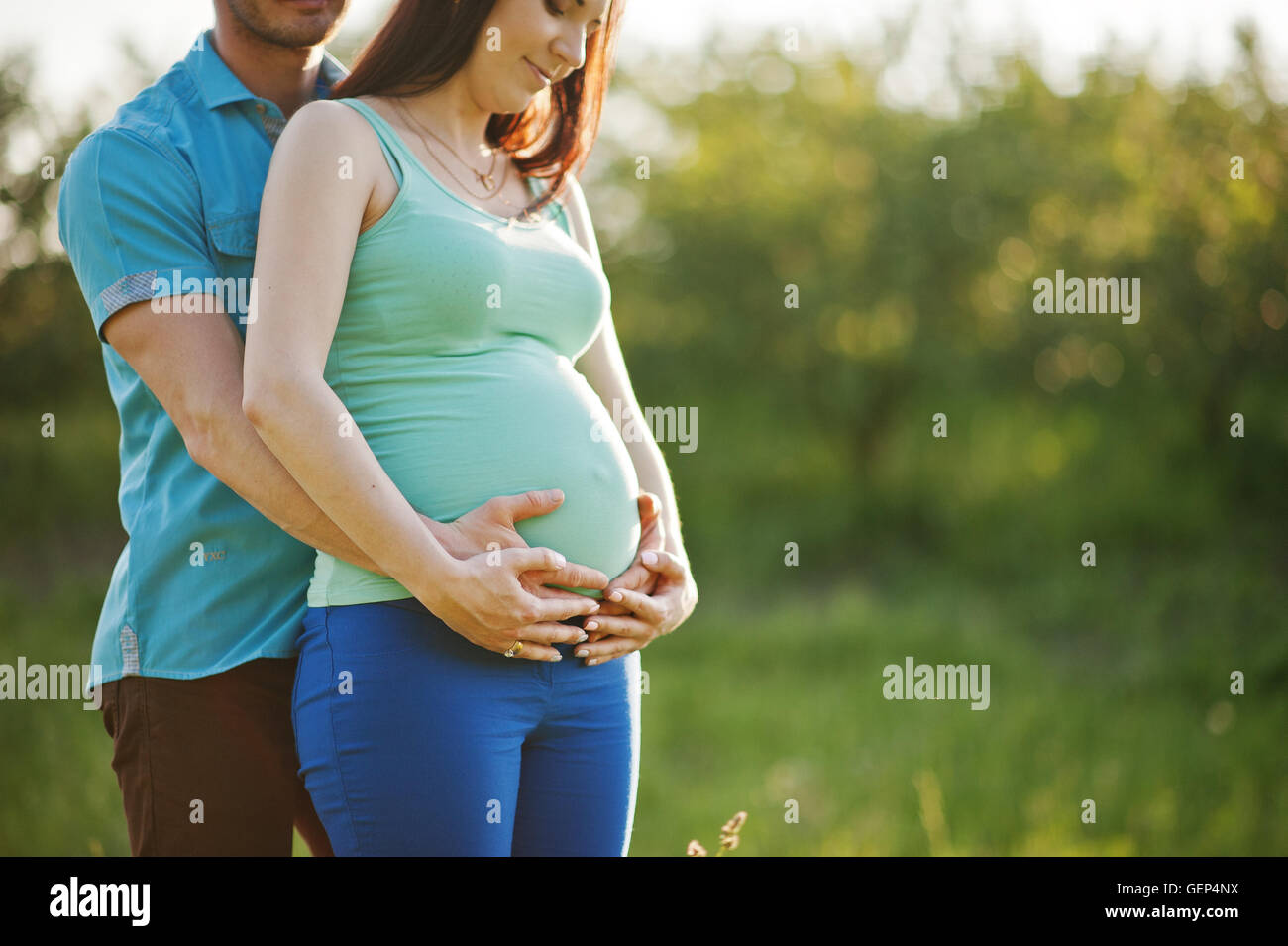 Happy pregnant couple at garden on magestic sunset Stock Photo - Alamy