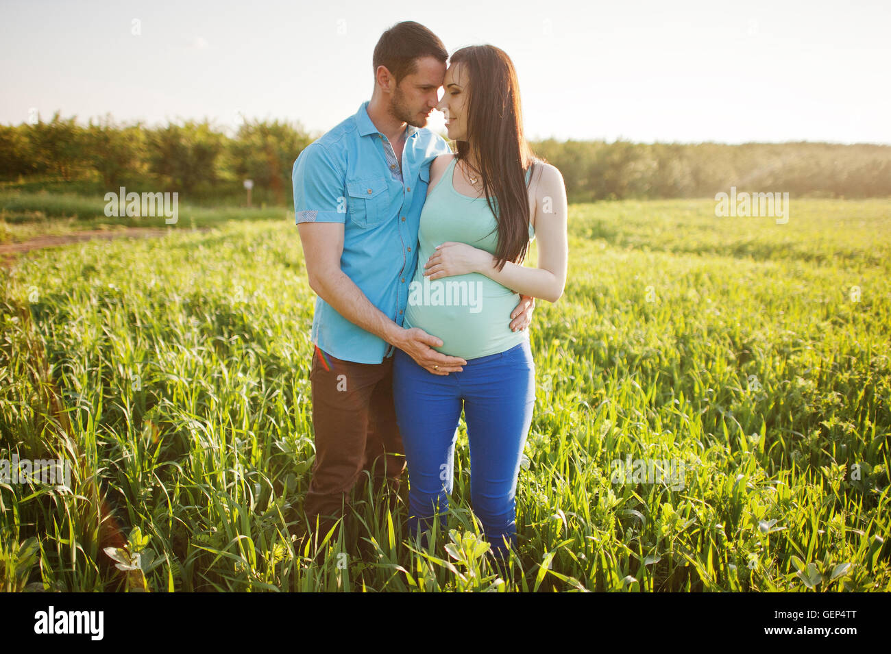 Happy pregnant couple at garden on magestic sunset Stock Photo - Alamy