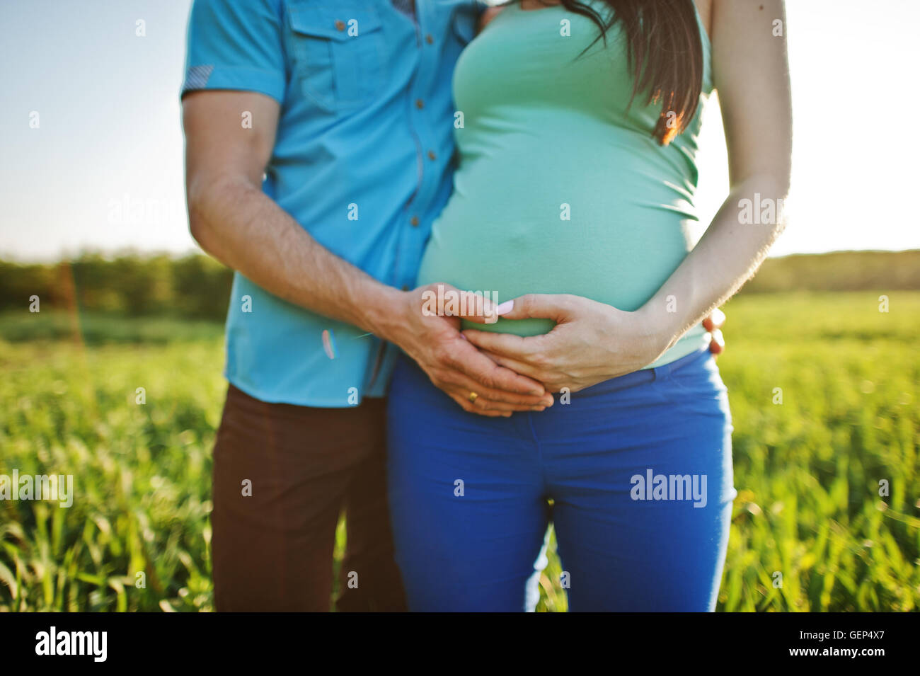 Happy pregnant couple at garden on magestic sunset Stock Photo - Alamy