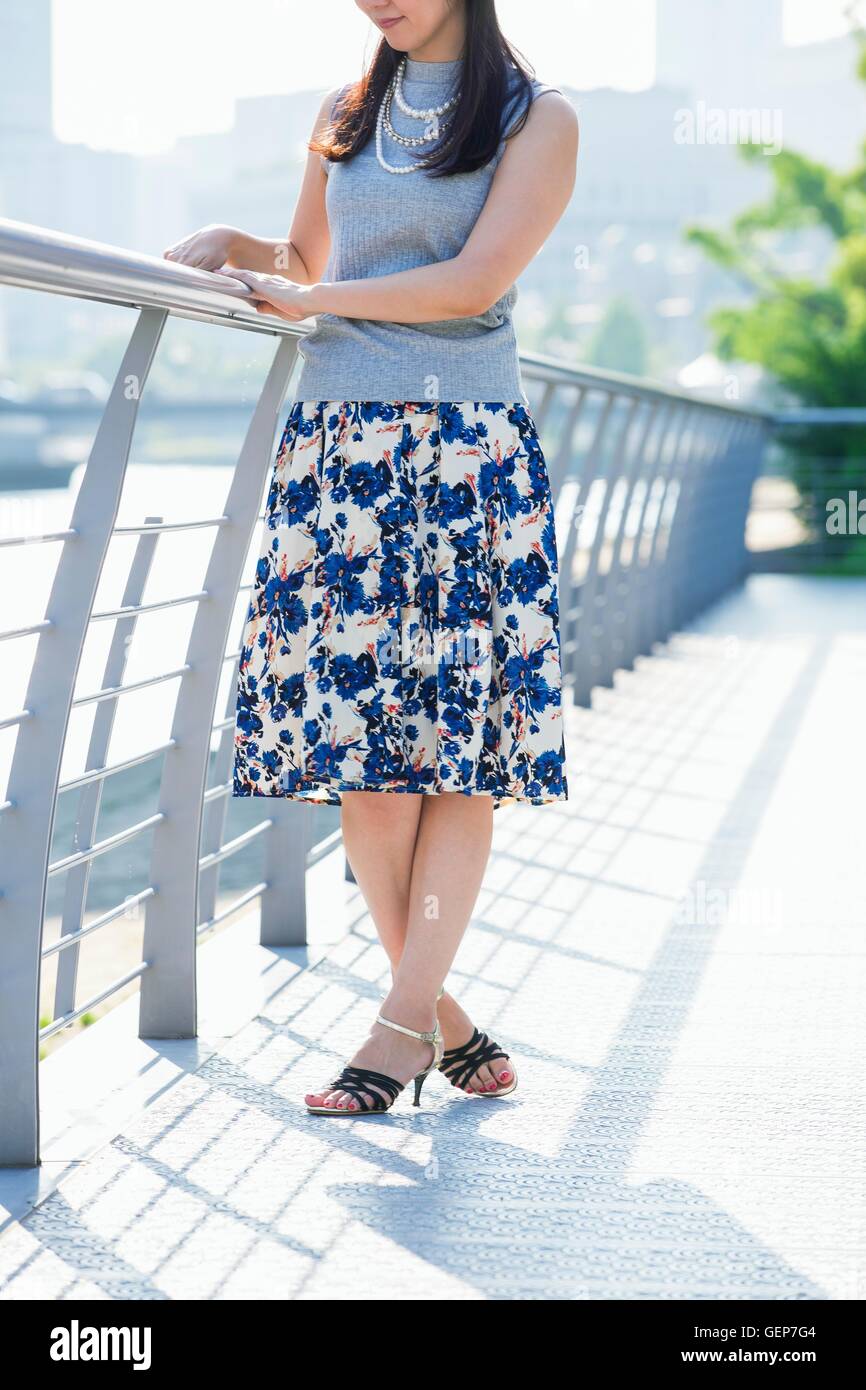 Woman standing at river side in the town Stock Photo - Alamy