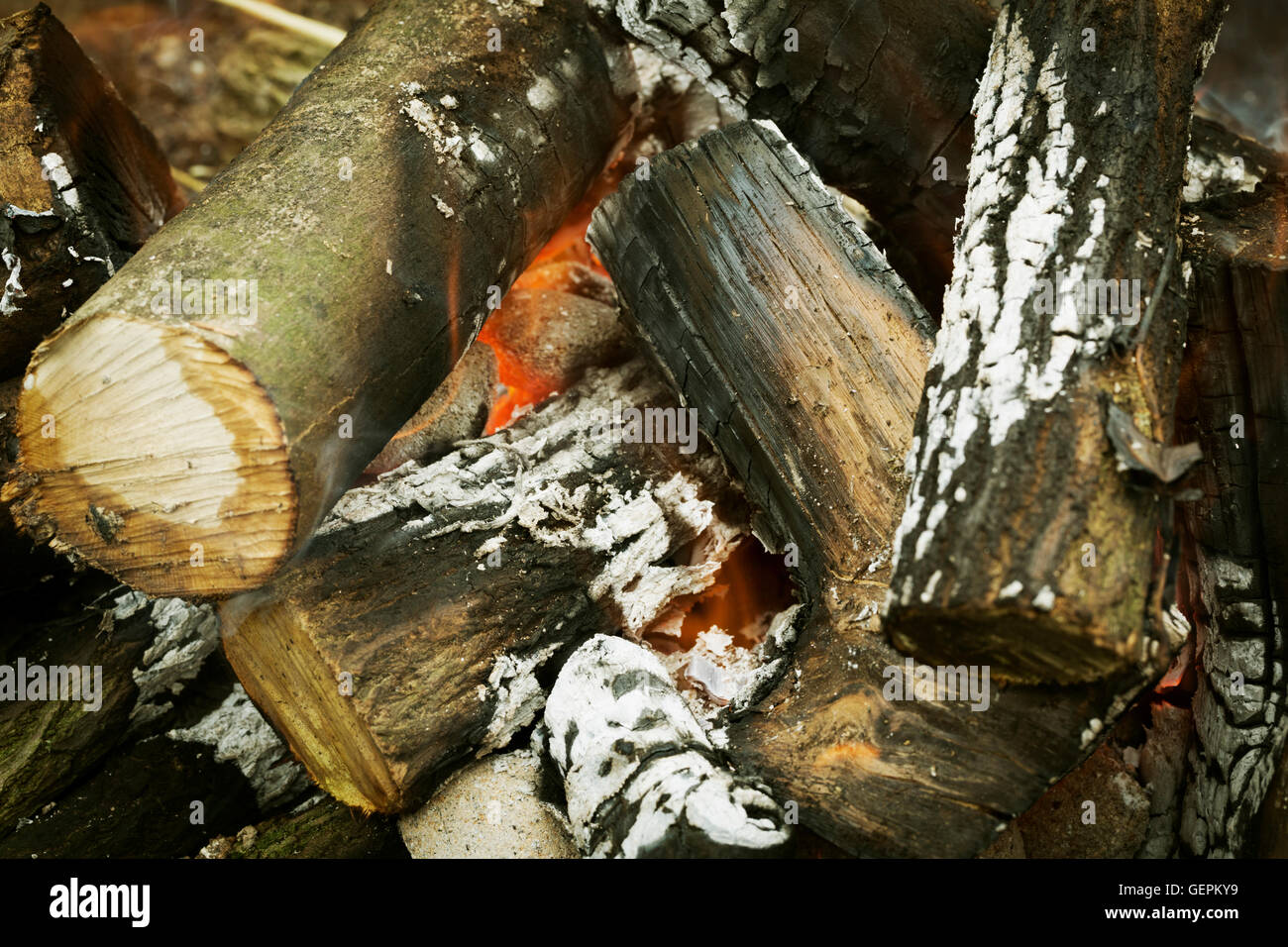 A log fire in a fire pit, with glowing embers. Stock Photo