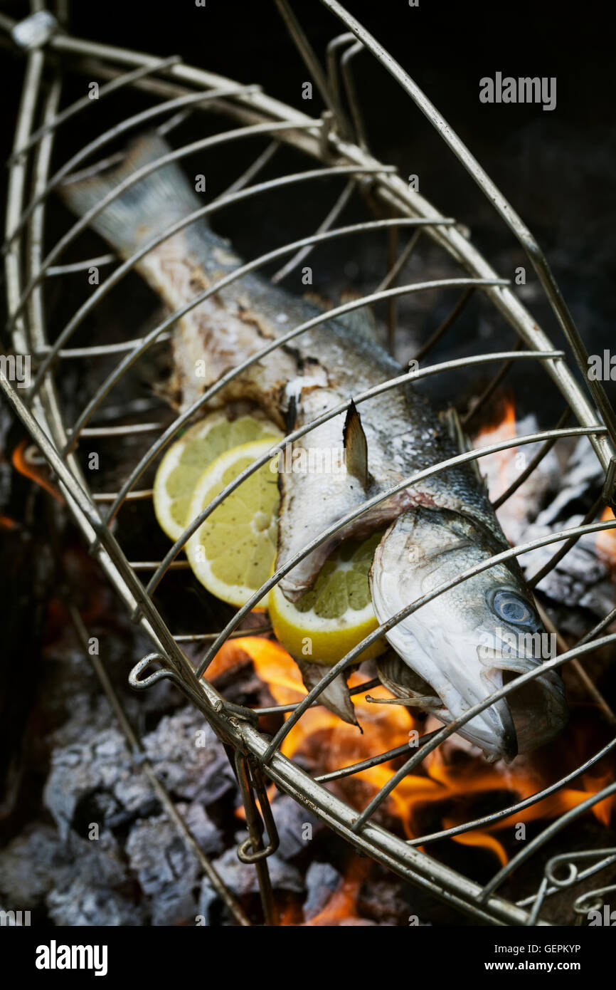 Fish in a fish grill basket over a barbecue Stock Photo Alamy