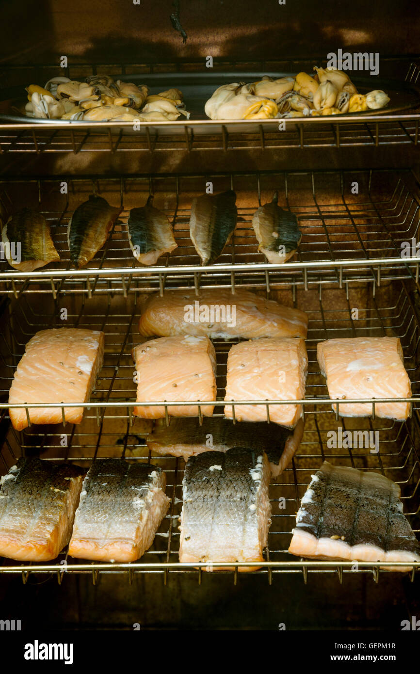Fish fillets on racks in a fish smoker. Stock Photo