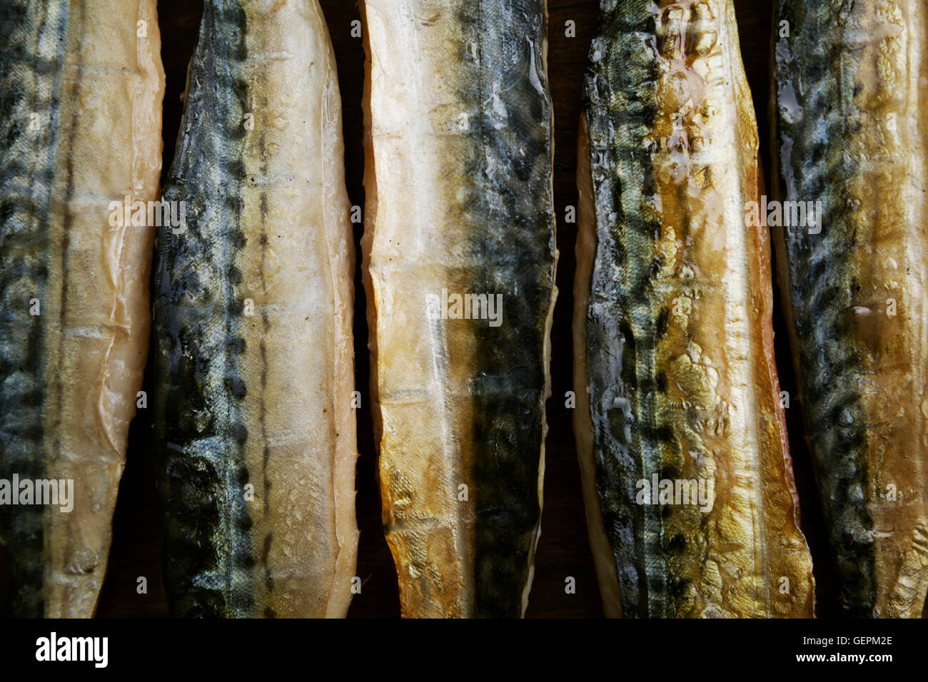 Smoked fish fillets laid out in a row. Stock Photo