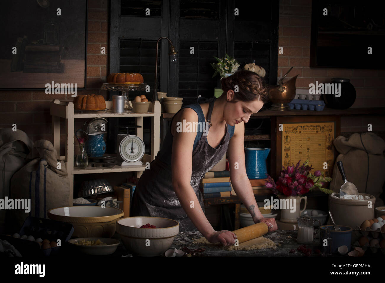 Valentine's Day baking, young woman standing in a kitchen, preparing dough for biscuits. Stock Photo