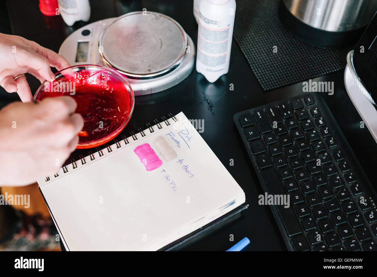 A colourist mixing hair dye using powder and water, and testing the