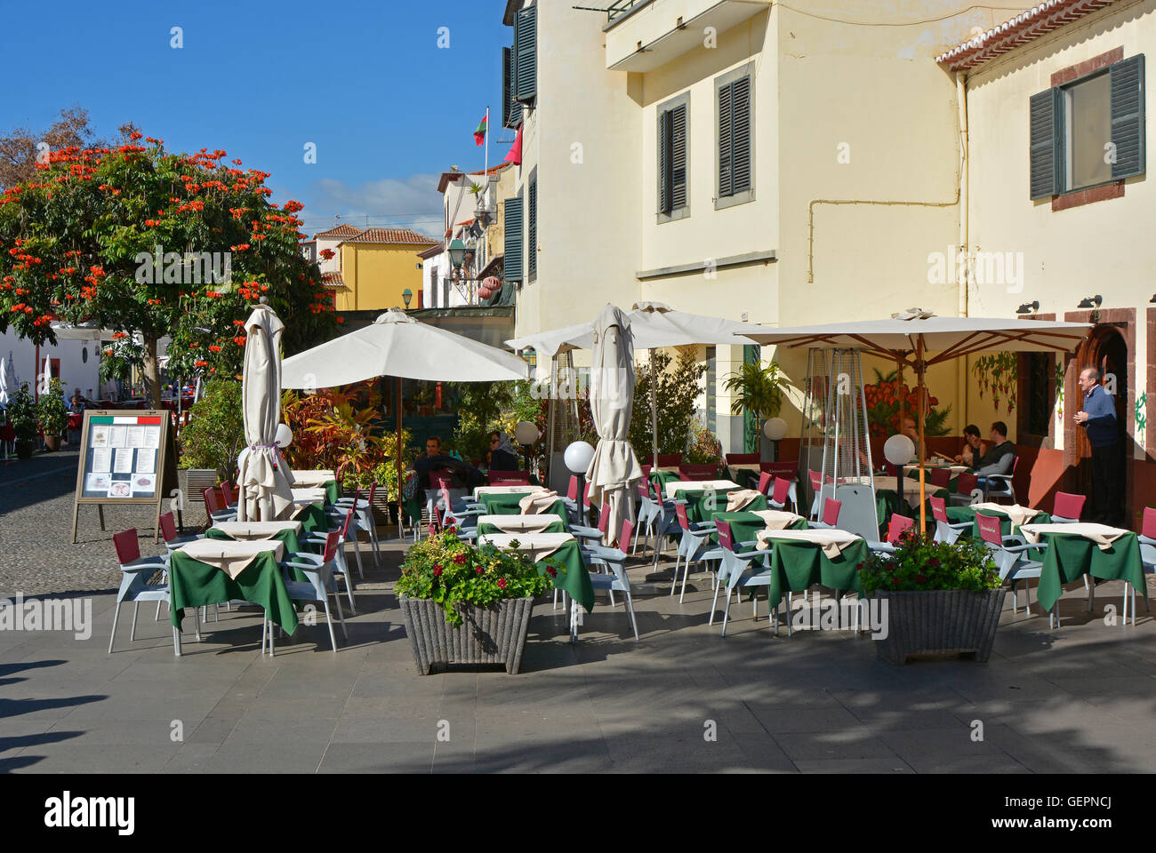 Restaurant terrace by square in old part of Funchal, Madeira, Portugal. With people seated at tables Stock Photo