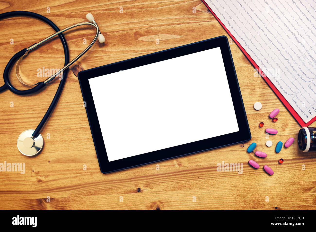 Tablet computer with blank screen on doctor's office desk as copy space, top view of general medical practitioner accessories in Stock Photo