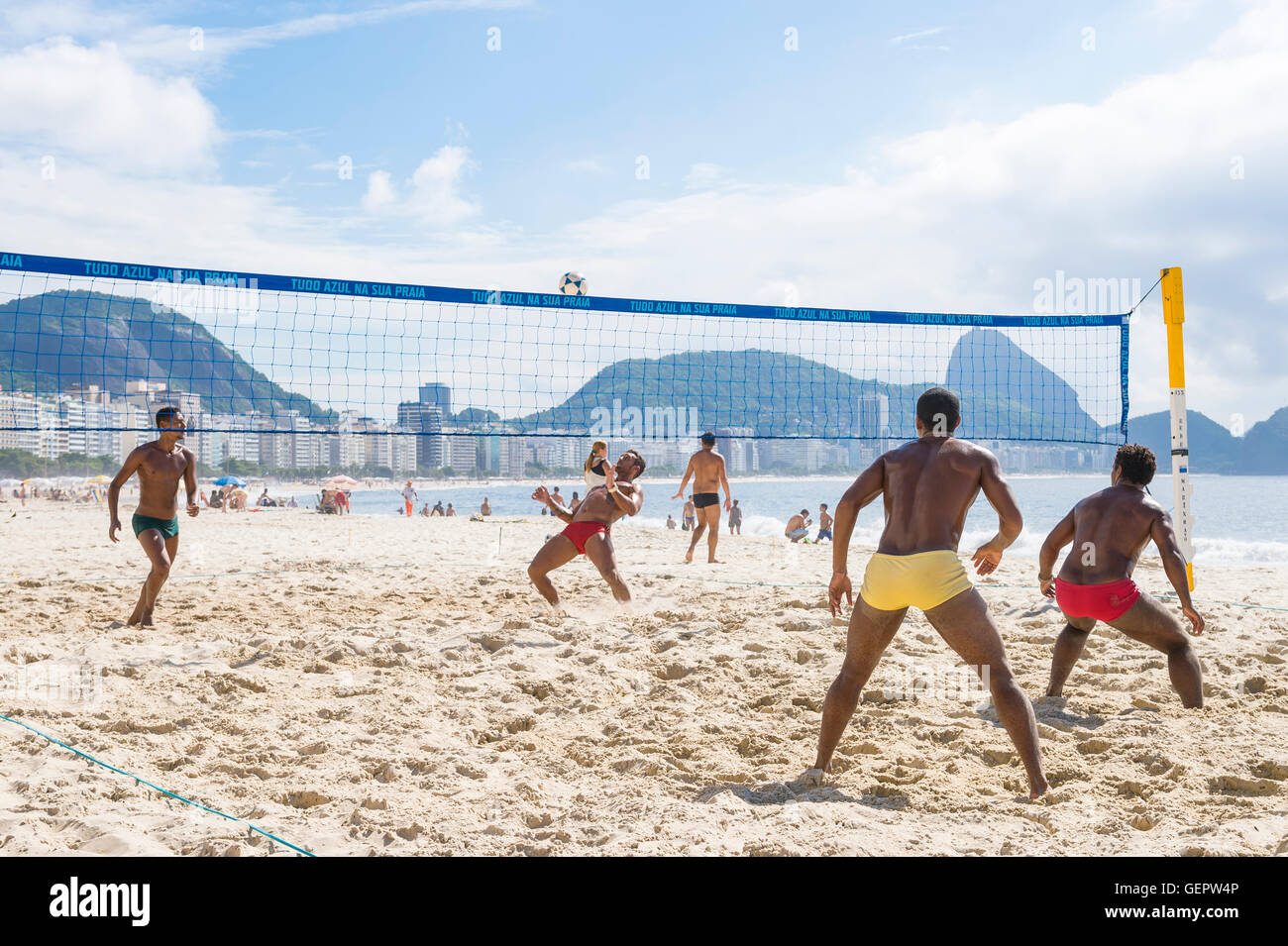 RIO DE JANEIRO - MARCH 15, 2016: Brazilian men play a game of futevôlei (footvolley, a sport combining football and volleyball). Stock Photo
