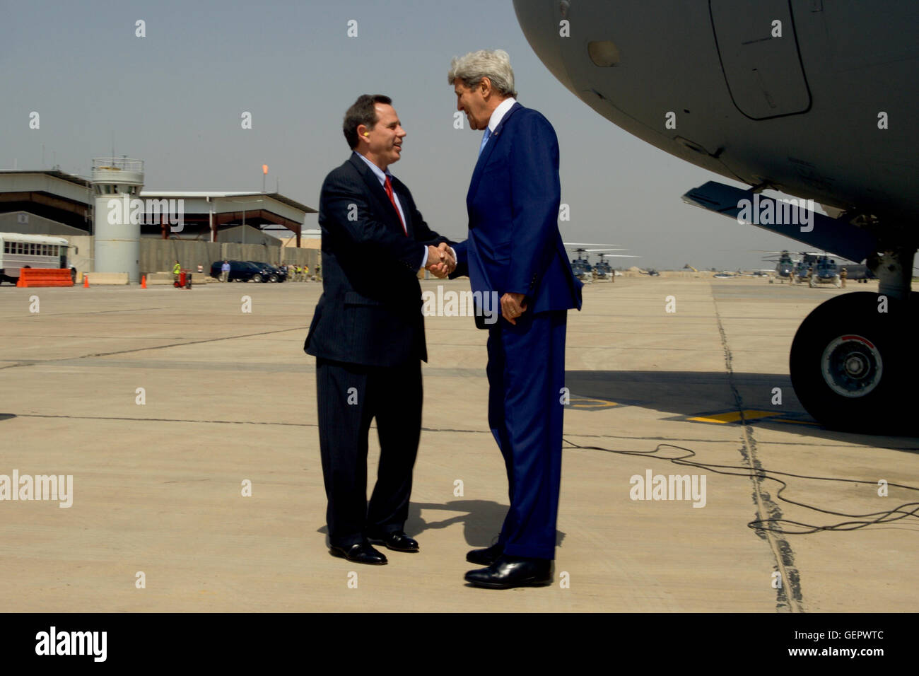 Secretary Kerry Shakes Hands With U.S. Ambassador to Iraq Jones After Disembarking From a C-17 Aircraft Upon Landing in Baghdad Stock Photo