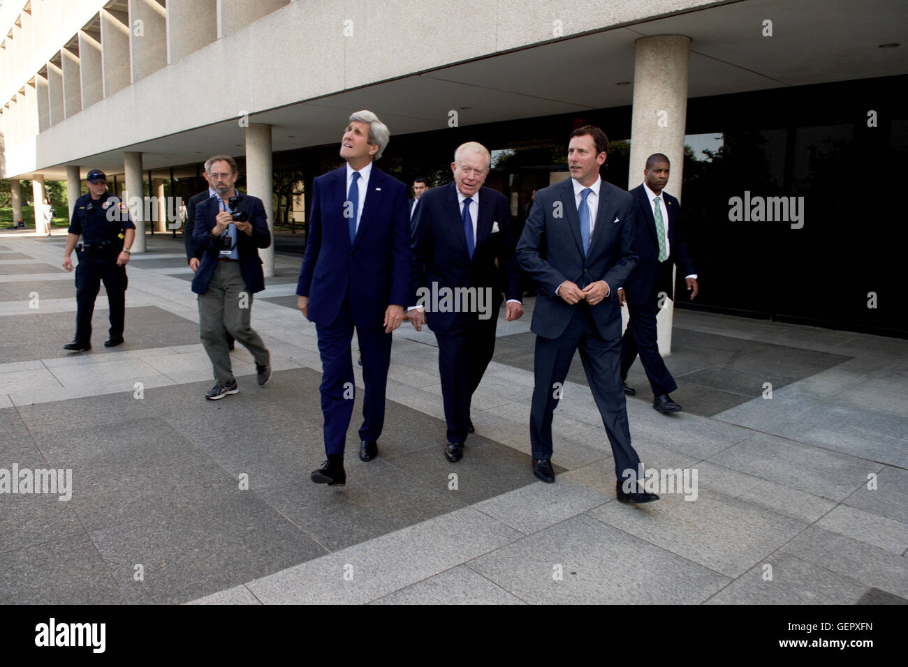 Secretary Kerry Walks With LBJ Presidential Library Vice Chairman Barnes and Library Director Updegrove Outside the LBJ School of Public Affairs at the University of Texas at Austin Stock Photo