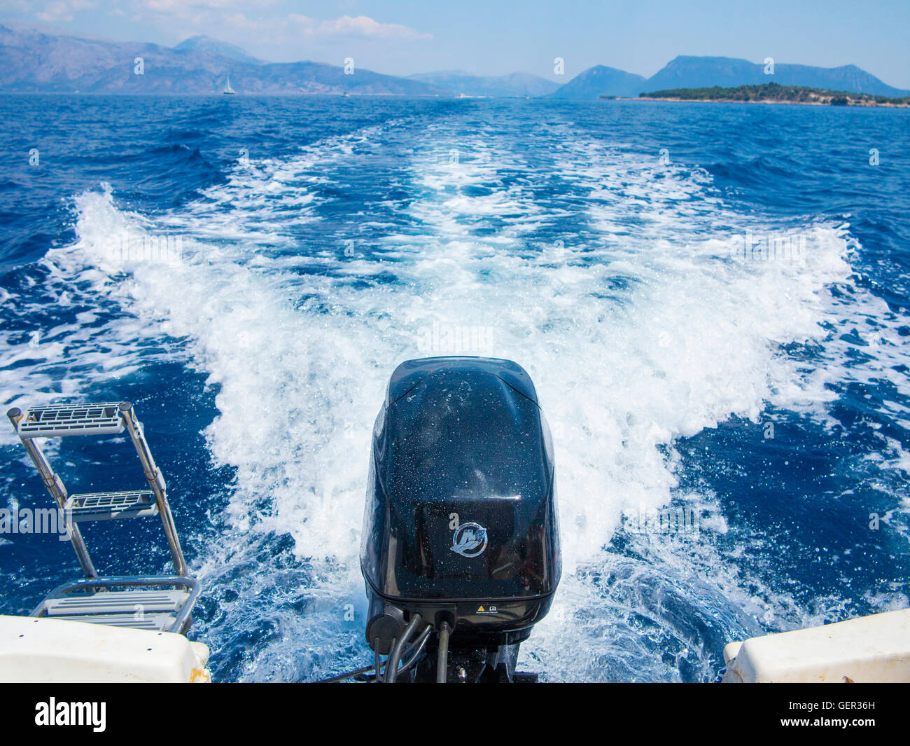 An outboard engine and it;s wake in a blue sea Stock Photo