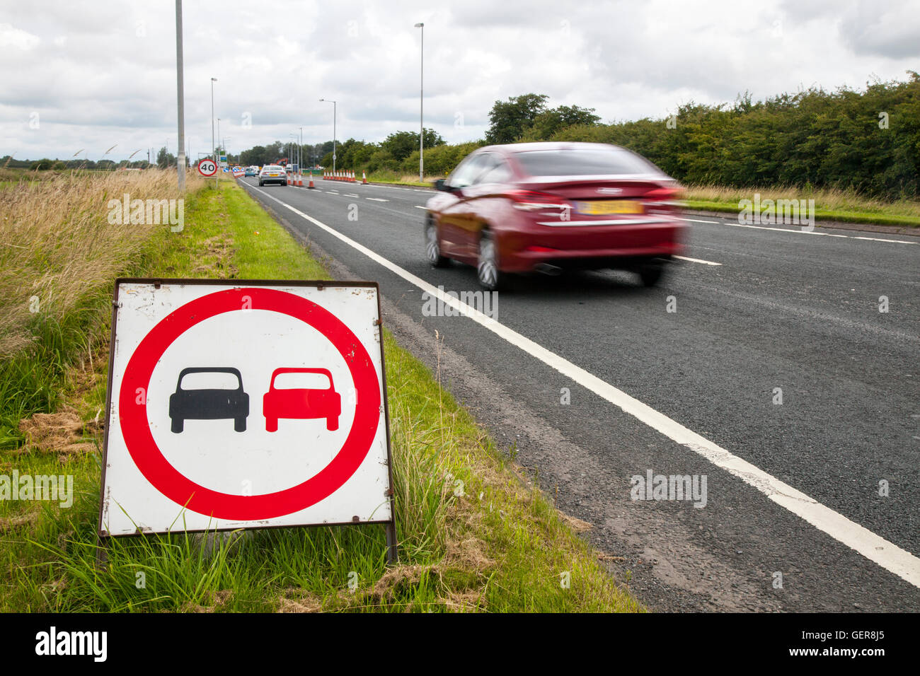 No overtaking signs, road markings, Laws and rules for overtaking in restricted areas; Chapter 8 Traffic Management systems in place on major long-term road works and temporary traffic lights on Preston arterial road, B5253 Flensburg Way in Farington Moss, Lancashire, UK. Stock Photo