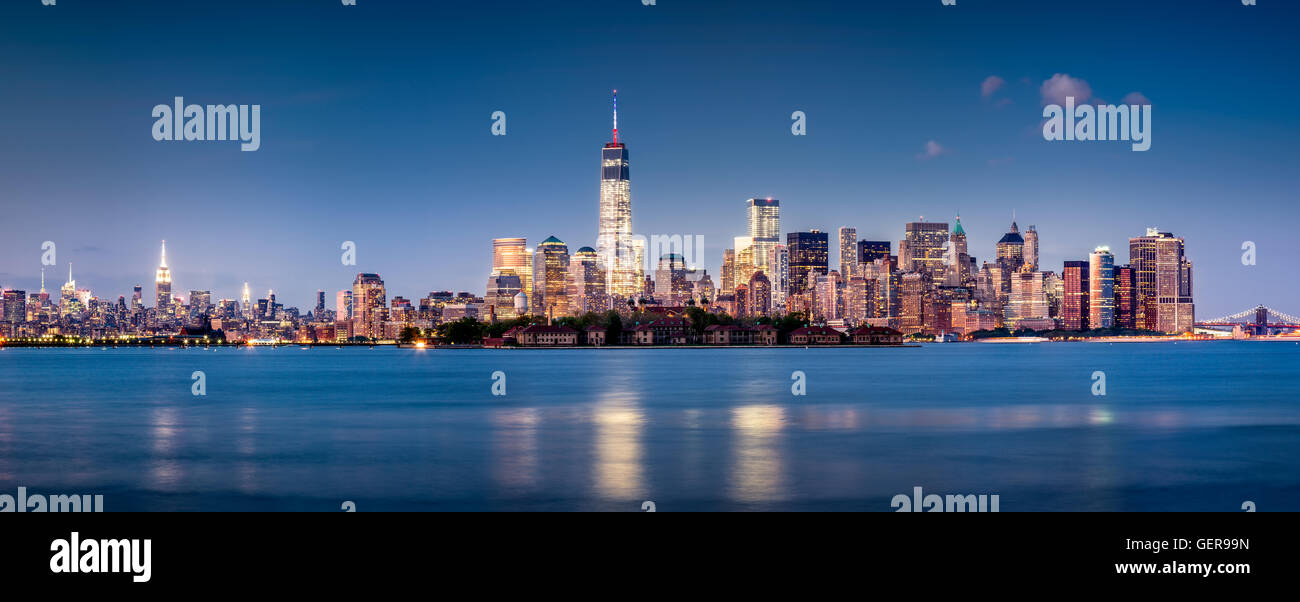 Panoramic Financial District of Lower Manhattan at twilight with Ellis Island and the World Trade Center. New York City Stock Photo