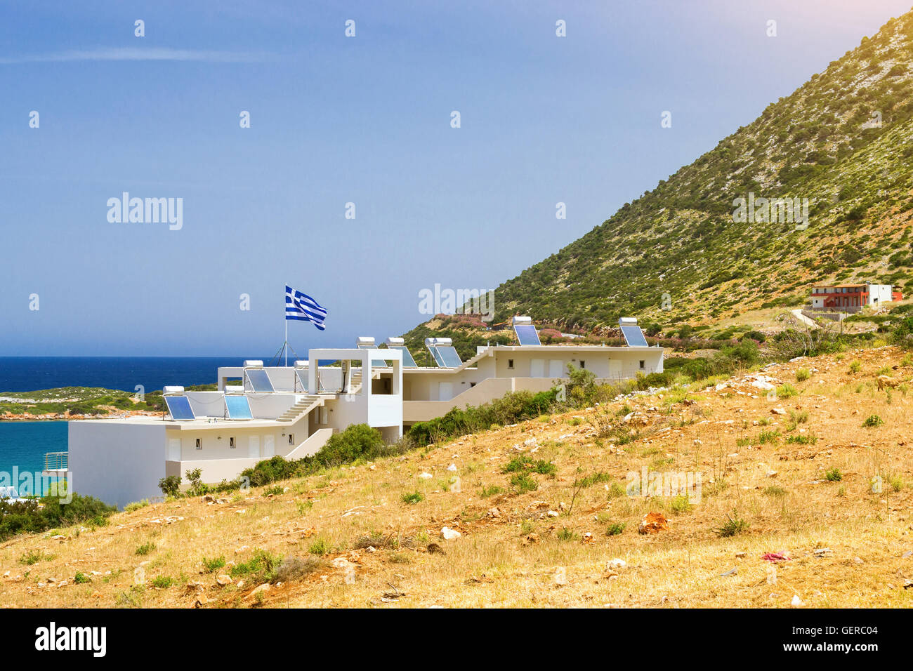 Modern Greek architecture, new white building in constructivist style, stands on shore of Cretan sea on roof mounted solar panel Stock Photo