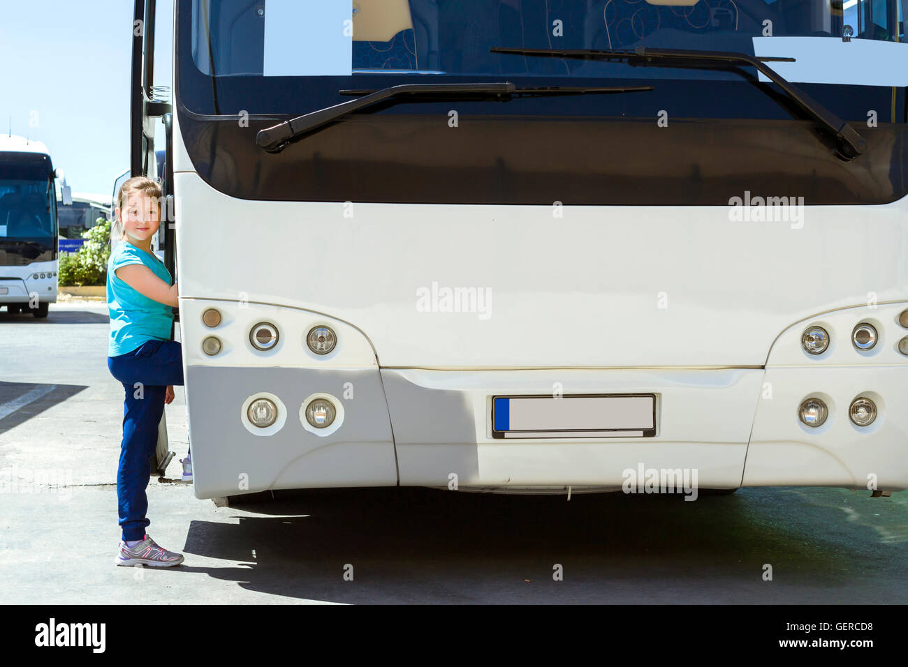 Girl posing near modern white tourist bus, transport parked at Heraklion Airport N. Kazantzakis, Crete, Greece Stock Photo