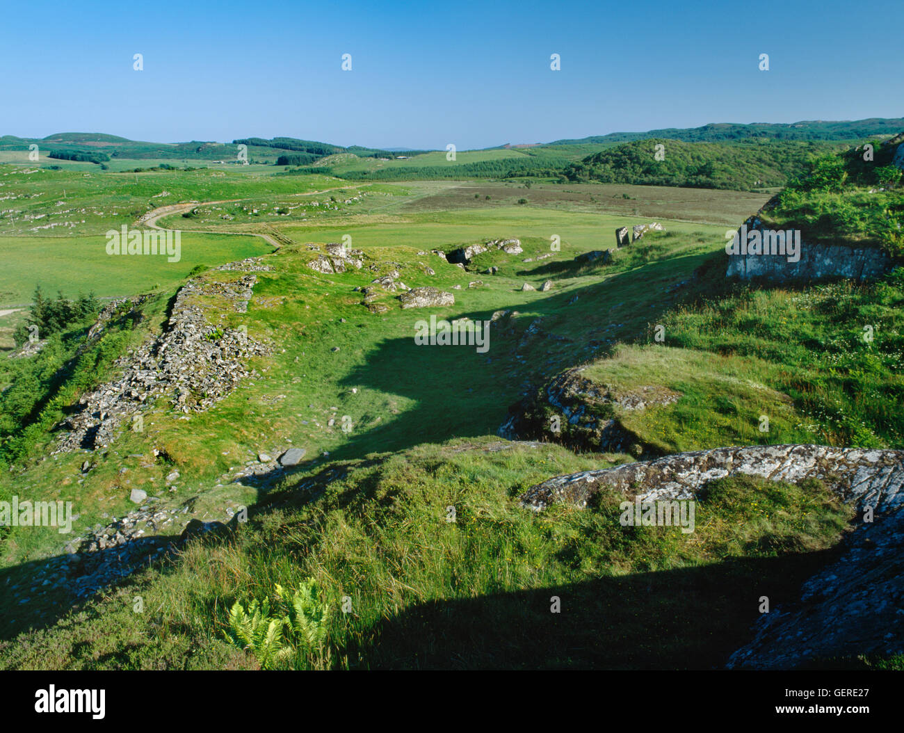 View SSE from upper terraces of Dunadd Dark Age fortress, Argyll, over massive wall (L) & entrance (centre rear) of the lower enclosure. Stock Photo