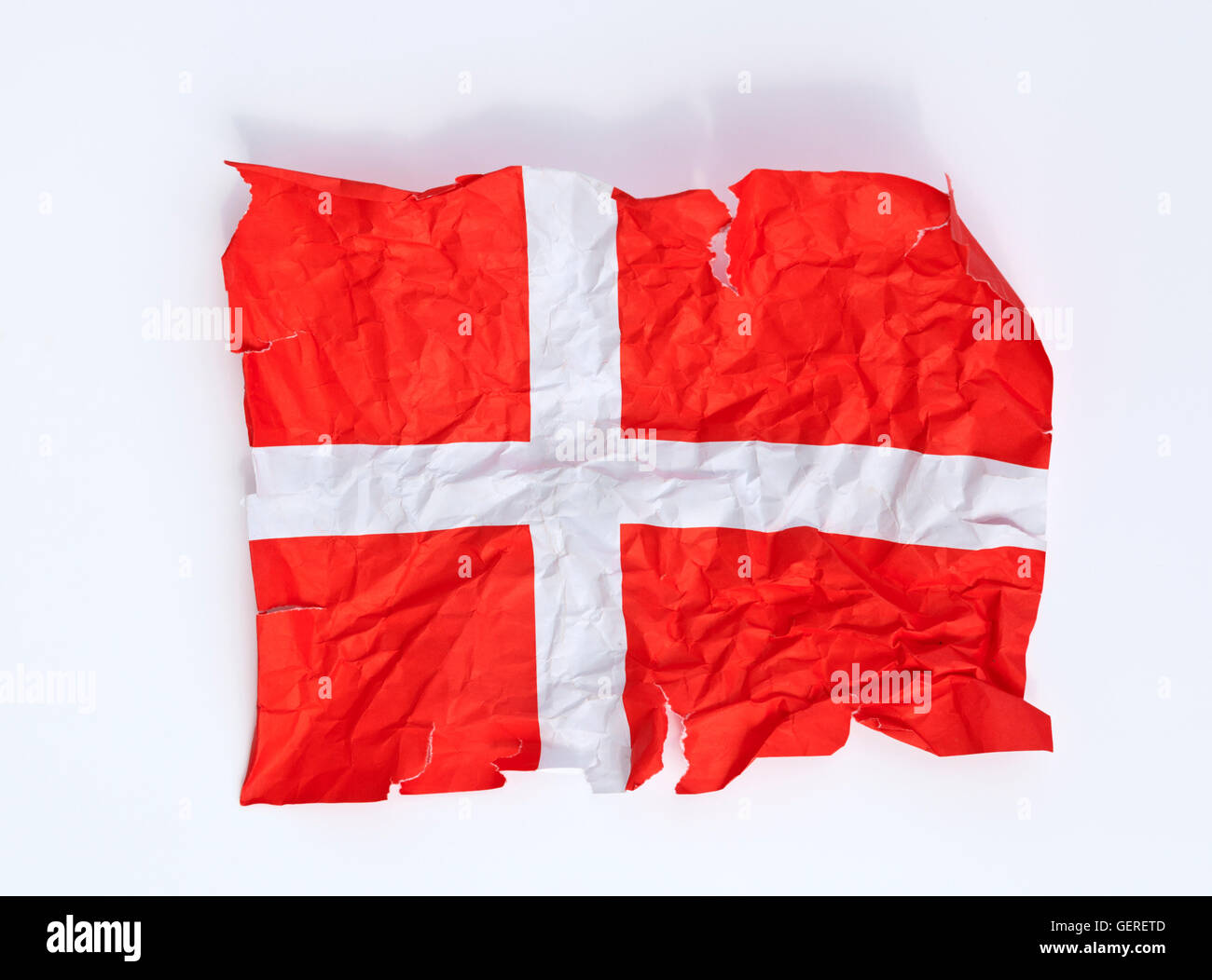 A crumpled, torn and distorted paper Dannebrog flag, the Danish flag. Close to being the happiest people? Stock Photo