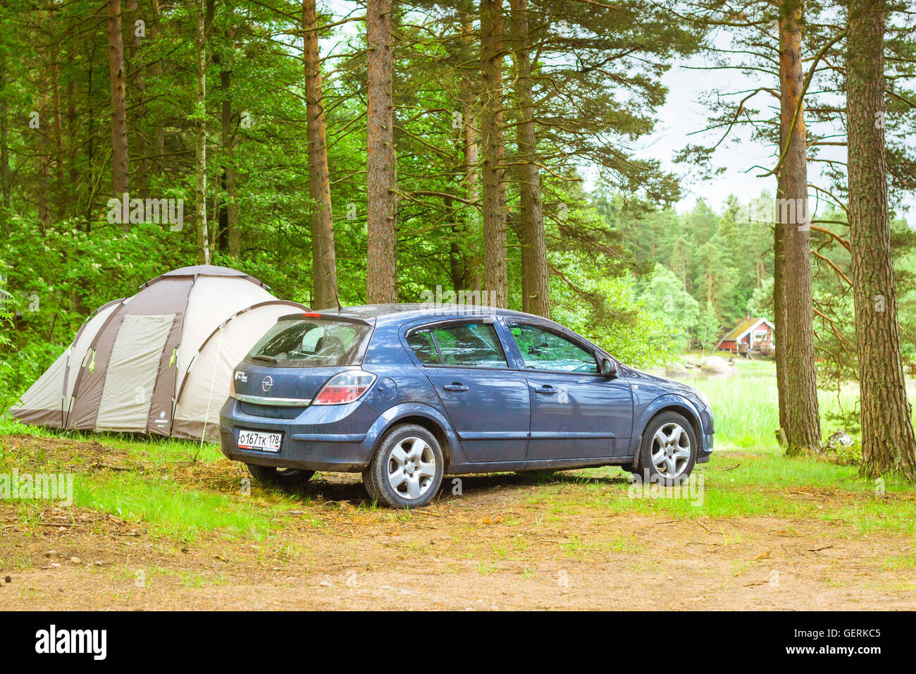 HAMINA, FINLAND - JUNE 13, 2014: Summer outdoor recreation, Scandinavian vacation. Car Opel Astra H parked in a wooded campsite Stock Photo