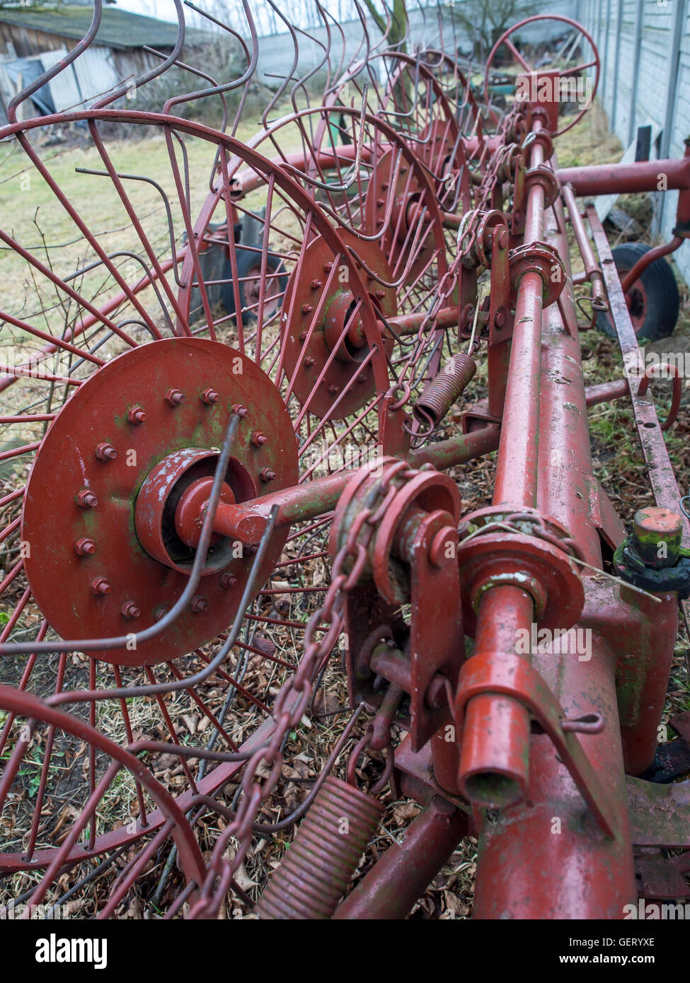 An agriculture machine being used to spread out hay Stock Photo