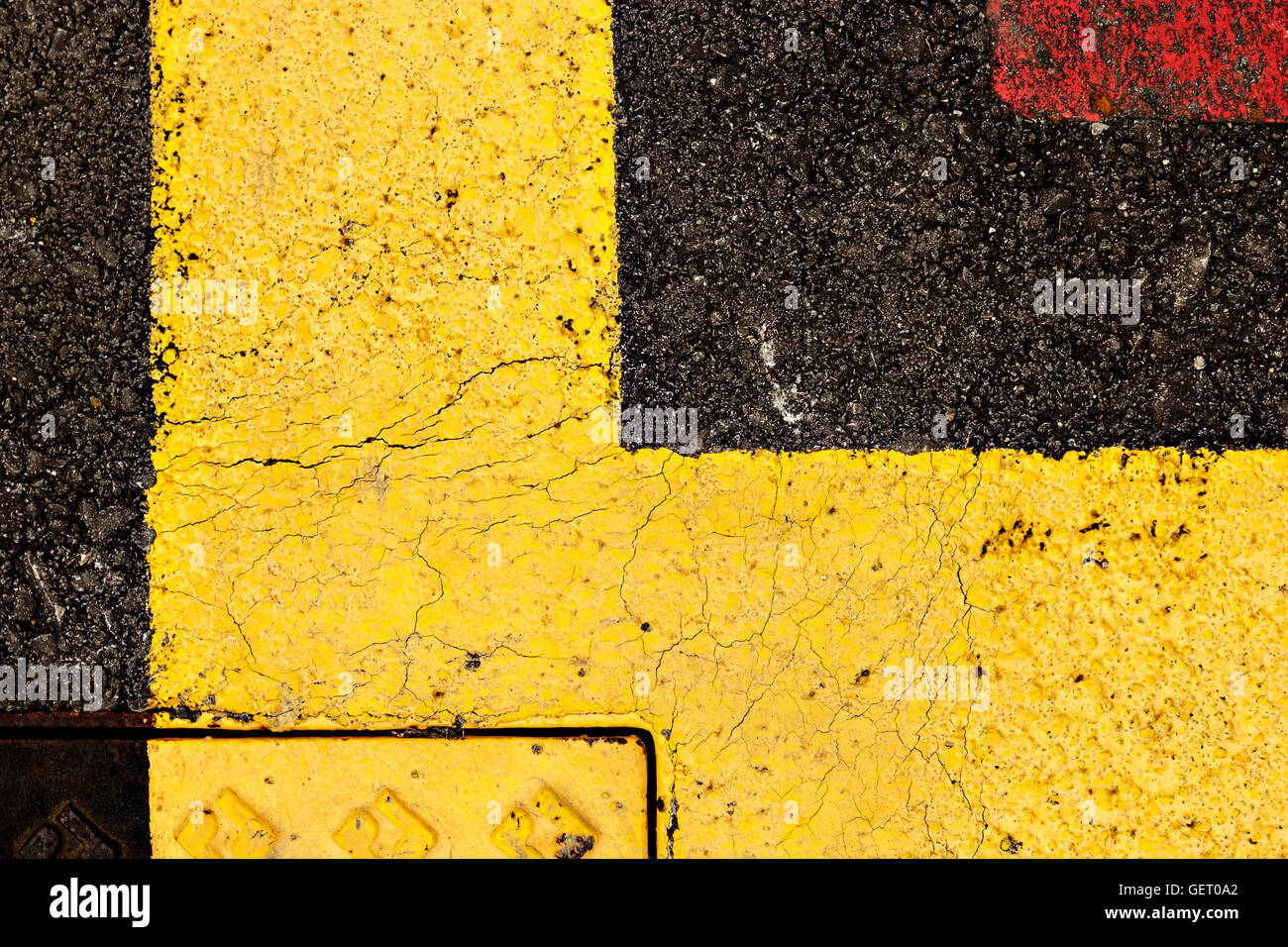 Asphalt painted yellow and red, suitable for textured abstract background. Horizontal image. Stock Photo