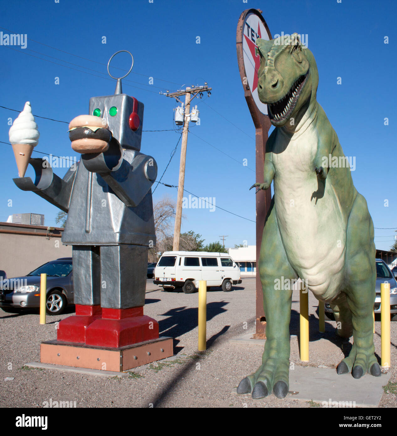 In Hatch, New Mexico, a robot with ice cream and a burger stands with a dinosaur and Robin Hood, creating a wild roadside restaurant scene. Stock Photo