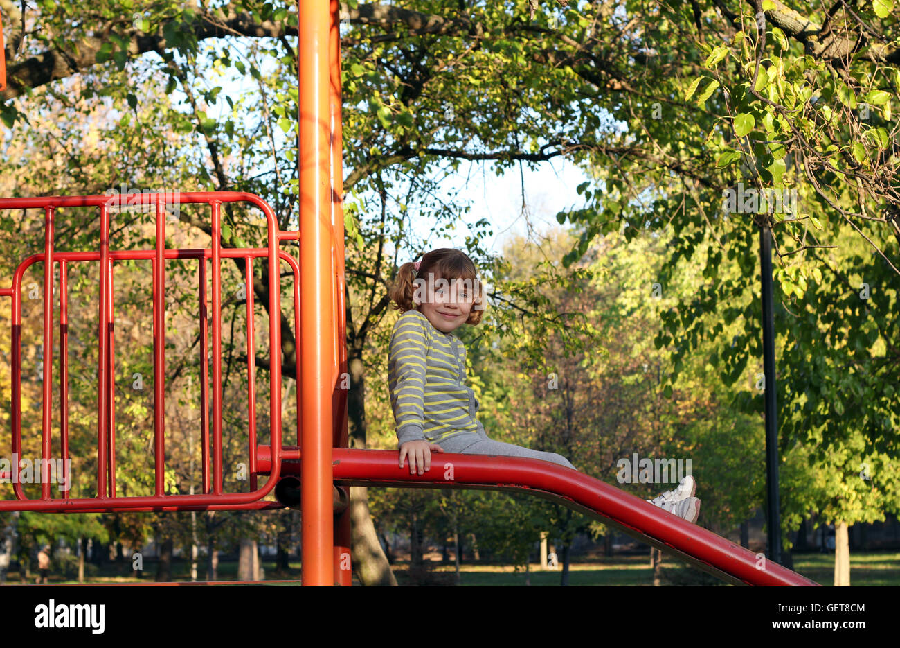 little girl sitting on playground slide Stock Photo - Alamy