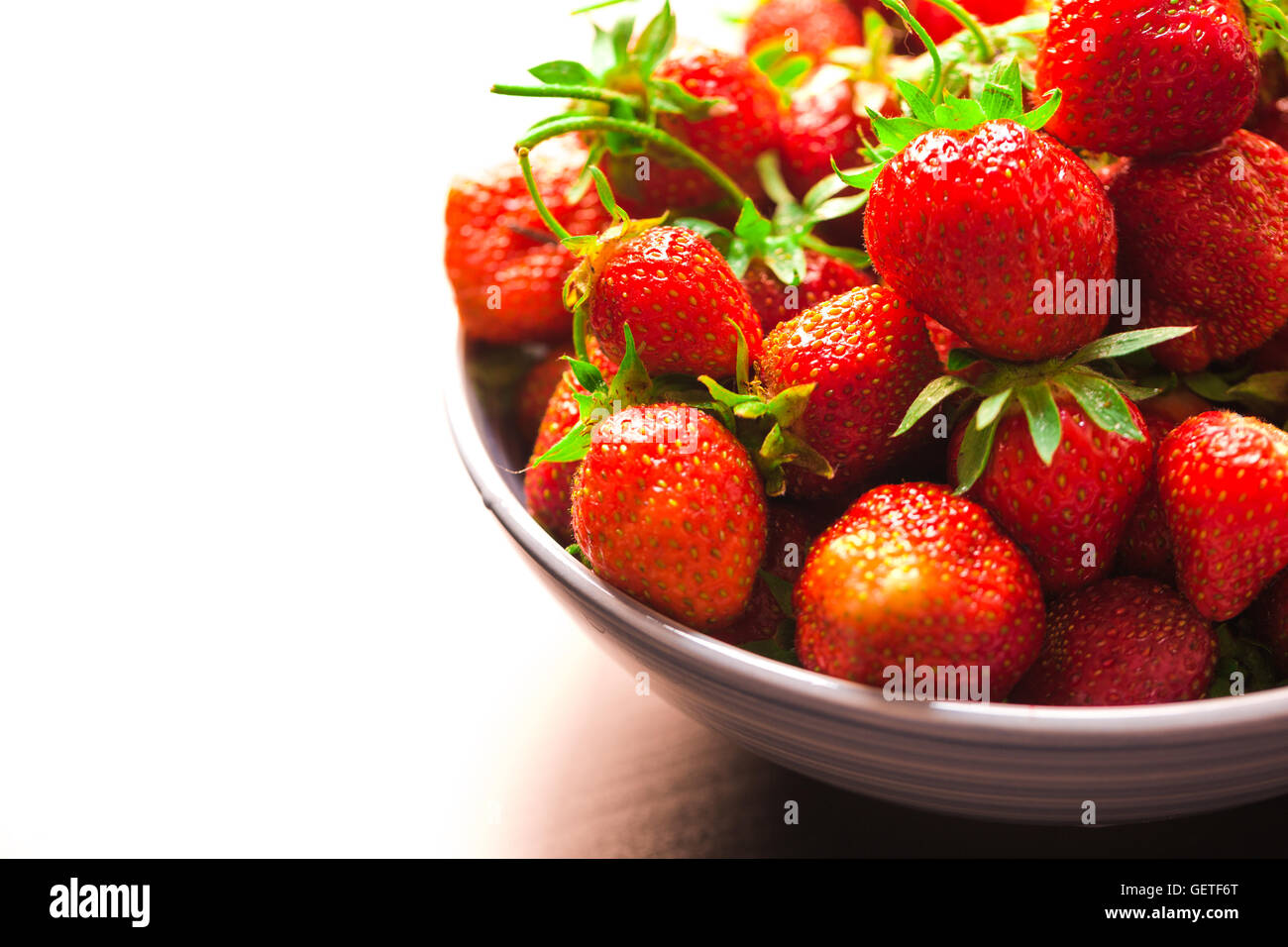 fresh strawberries in a blue plate on a blurred background Stock Photo ...
