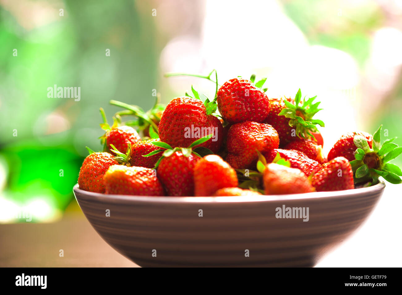 fresh strawberries in a blue plate on a blurred background Stock Photo ...