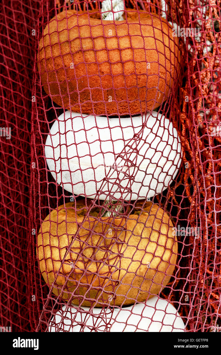 Red fishing net with white, orange and yellow corks in Santona