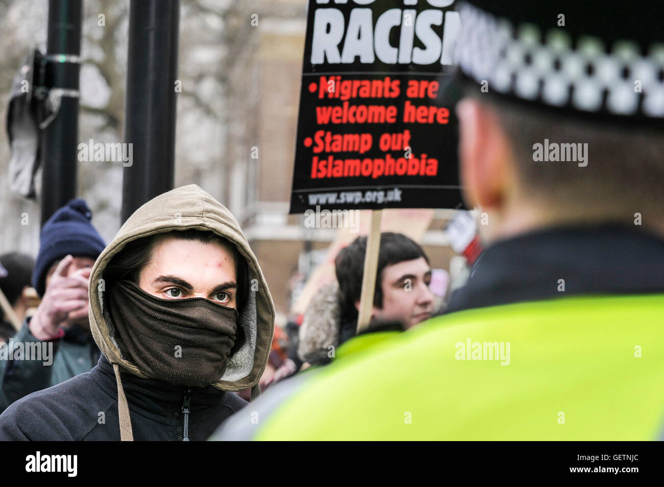 A masked anti-fascist demonstrator confonting a police cordon at a demonstration in Whitehall Stock Photo