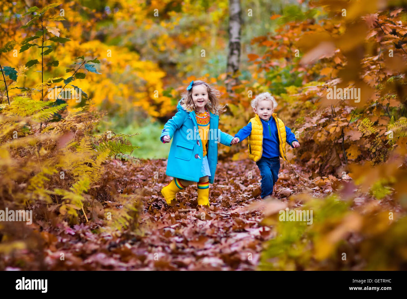 Happy children playing in beautiful autumn park on warm sunny fall day ...