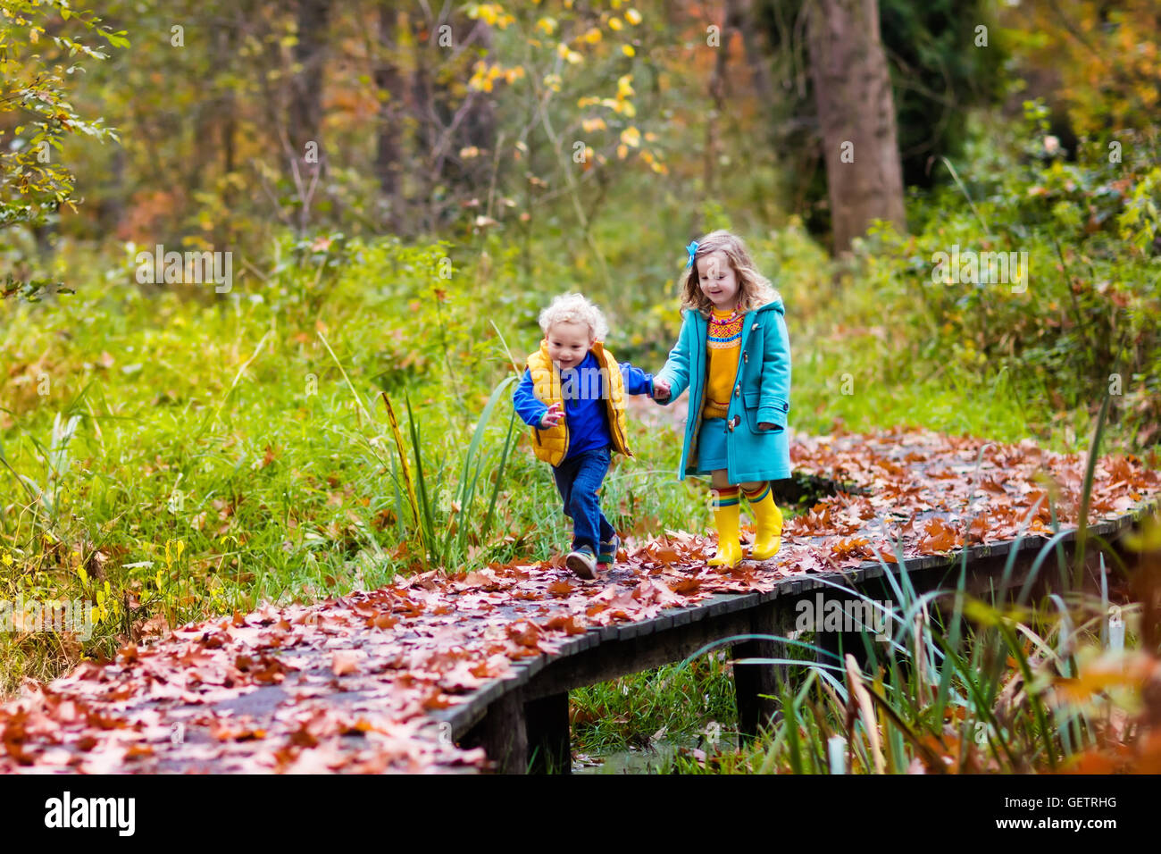 Happy children playing in beautiful autumn park on warm sunny fall day ...