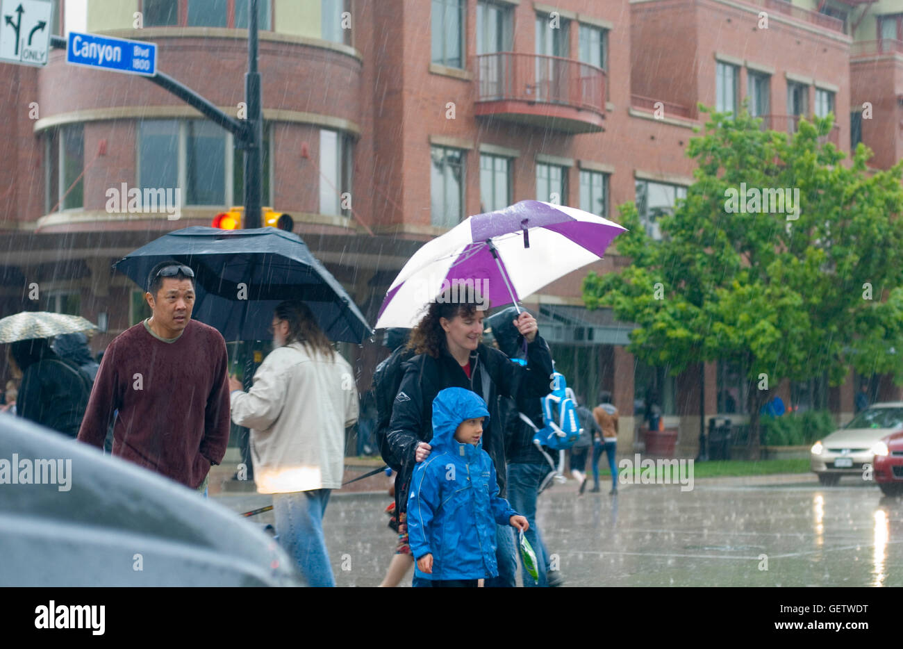 Pedestrians cross Canyon Blvd. in Boulder CO during a summer rain Stock Photo