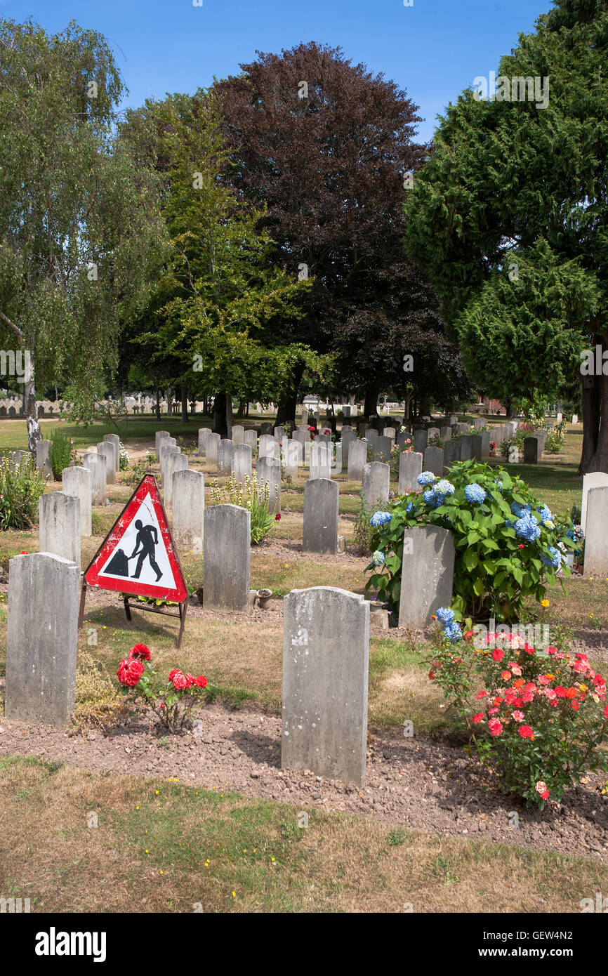 Men at work; men at rest: Clayhall Royal Naval Cemetery, Alverstoke, Gosport, Hants, England Stock Photo