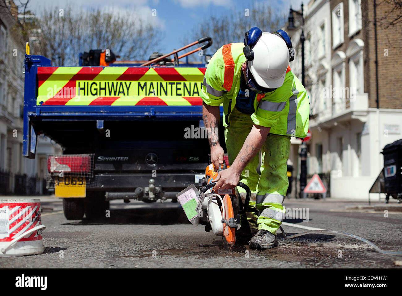 HIghway maintenance filling a pot hole in the city. Stock Photo