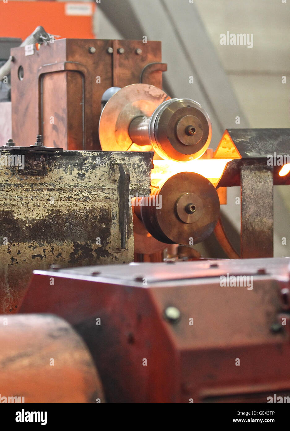 Moving the heated metal rod through the rollers in rolling mill Stock ...
