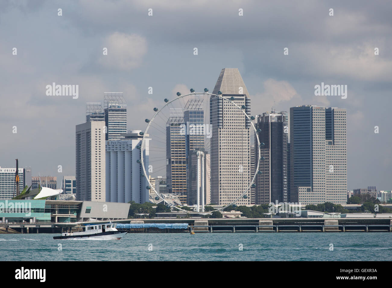 Skyline view of various commercial offices, hotels and Singapore flyer from the Straits of Singapore sea on a cloudy day. Marina Bay. Stock Photo