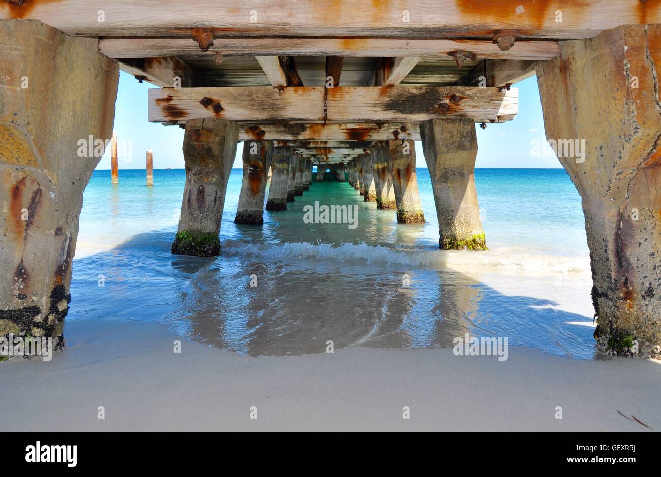 View through the underside of the Coogee Beach jetty structure with the Indian Ocean waters in Coogee, Western Australia. Stock Photo