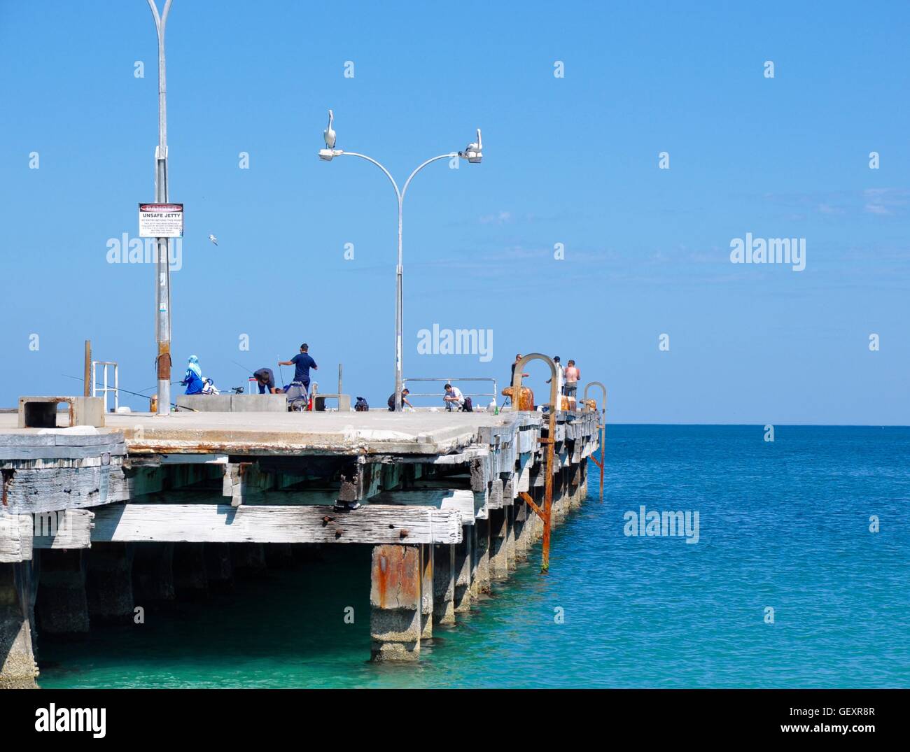 Coogee,WA,Australia-November 13,2015:People fishing on the Coogee Beach jetty with pelicans and Indian Ocean in Coogee,Western Australia Stock Photo