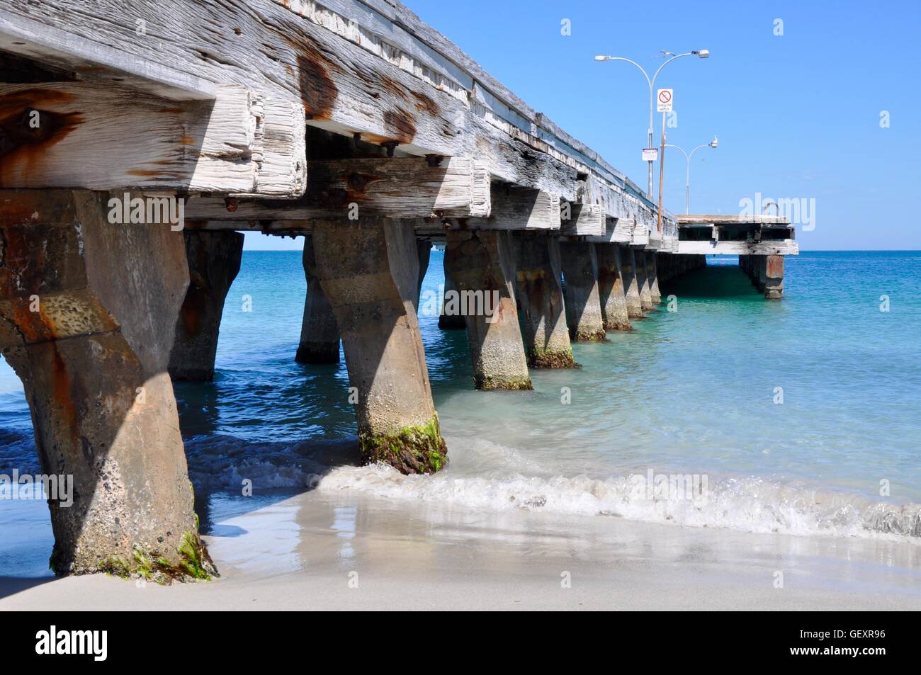 Coogee Beach jetty structure with turquoise Indian Ocean waters under a clear blue sky in Coogee, Western Australia. Stock Photo