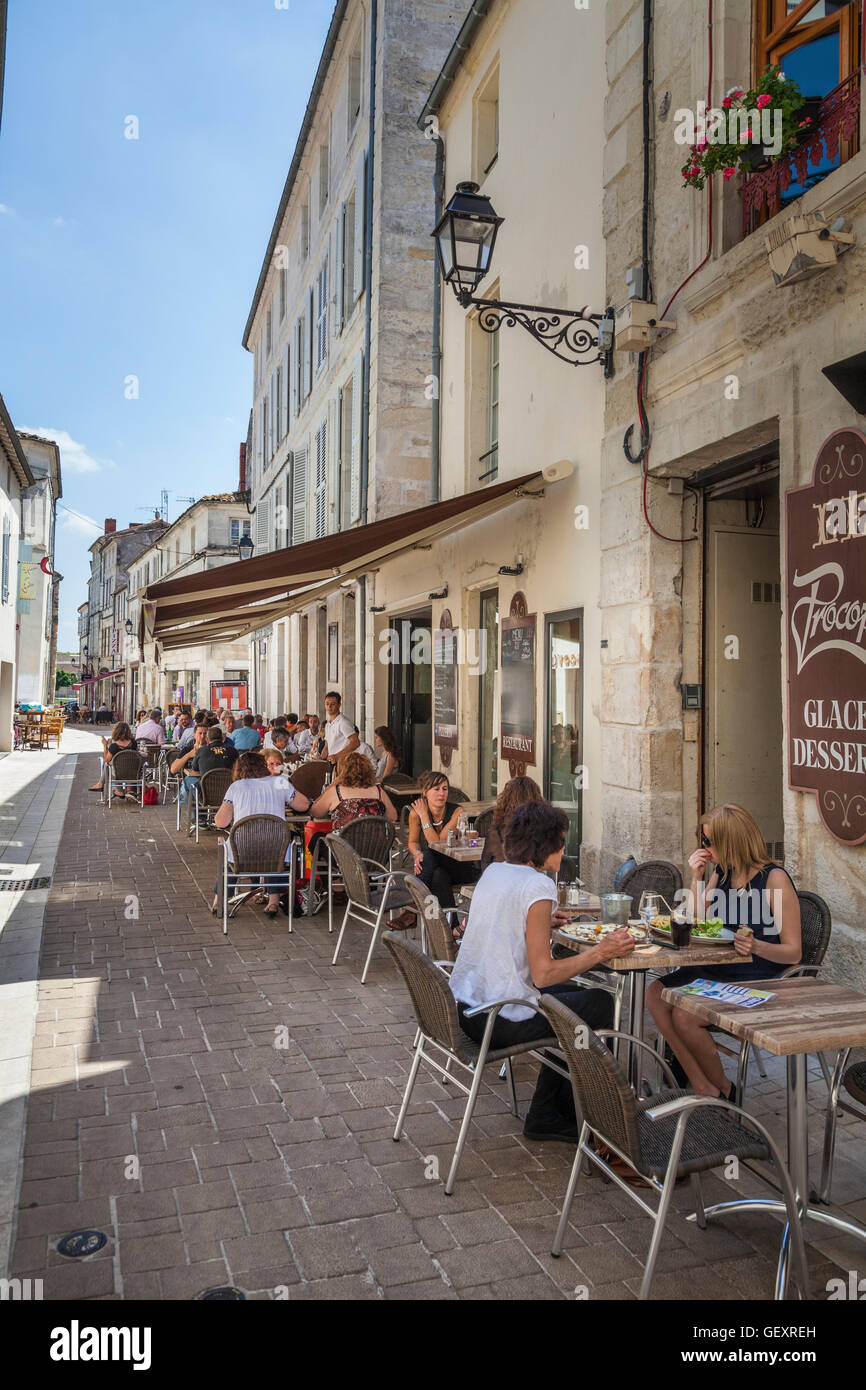 Busy French street restaurant in shady narrow street serving lunch ...