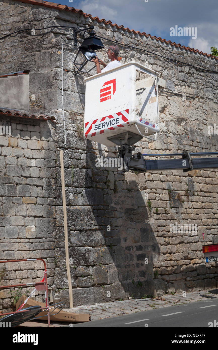 French workman on high lift repairing street light. Stock Photo