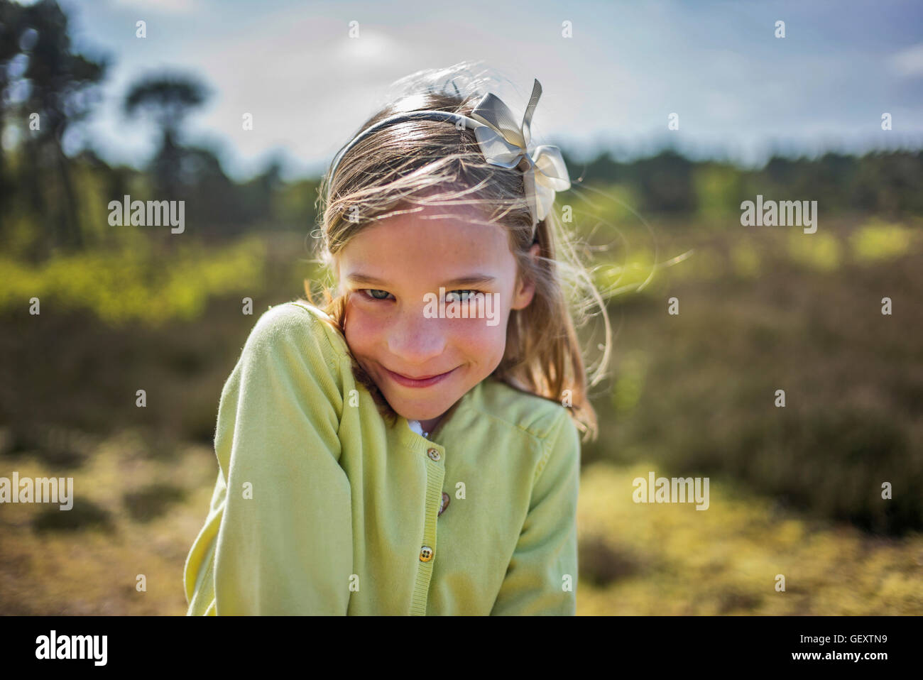 A young girl smiles cheekily at the camera. Stock Photo