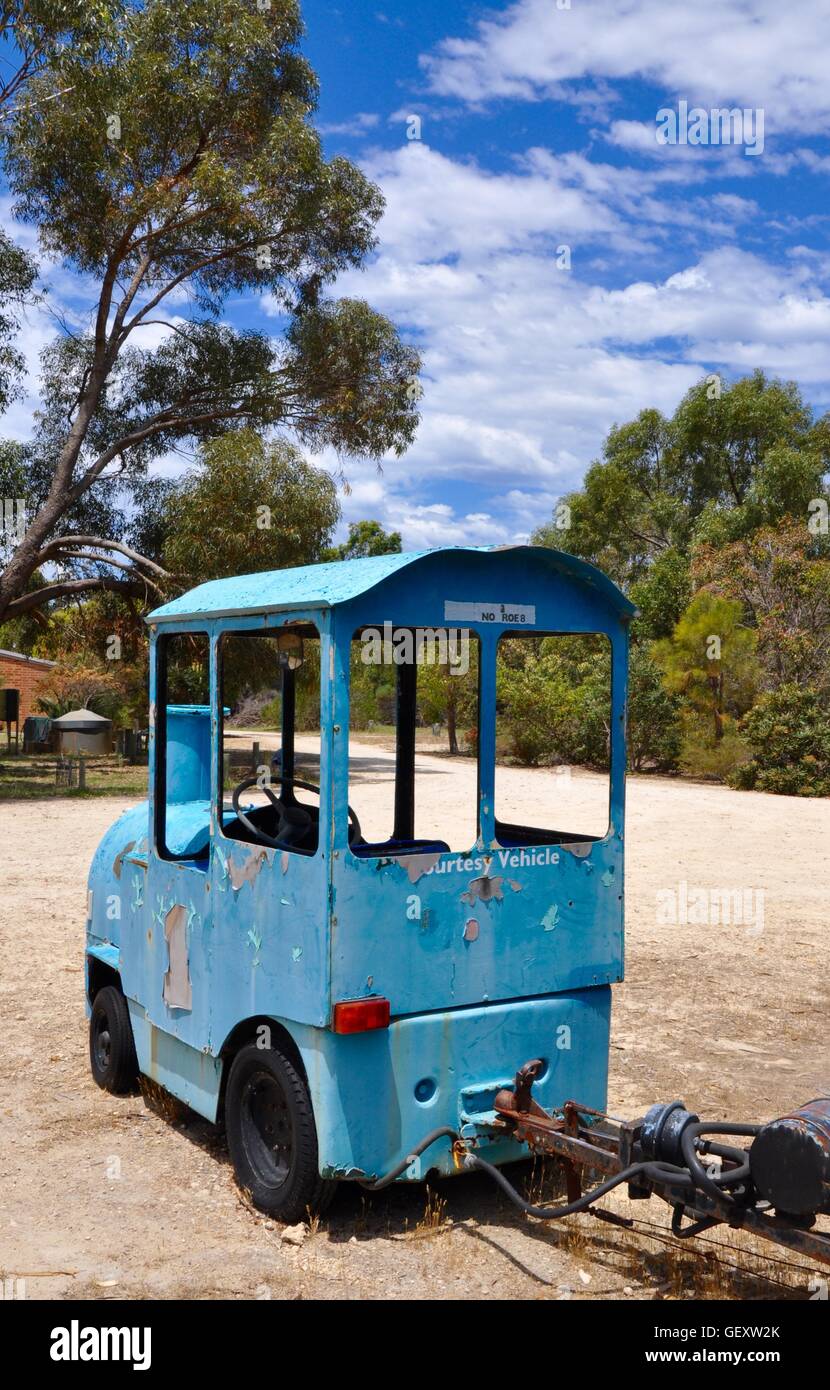 Old weathered metal retro blue touring train in the Bibra Lake reserve with native bushland in Western Australia. Stock Photo