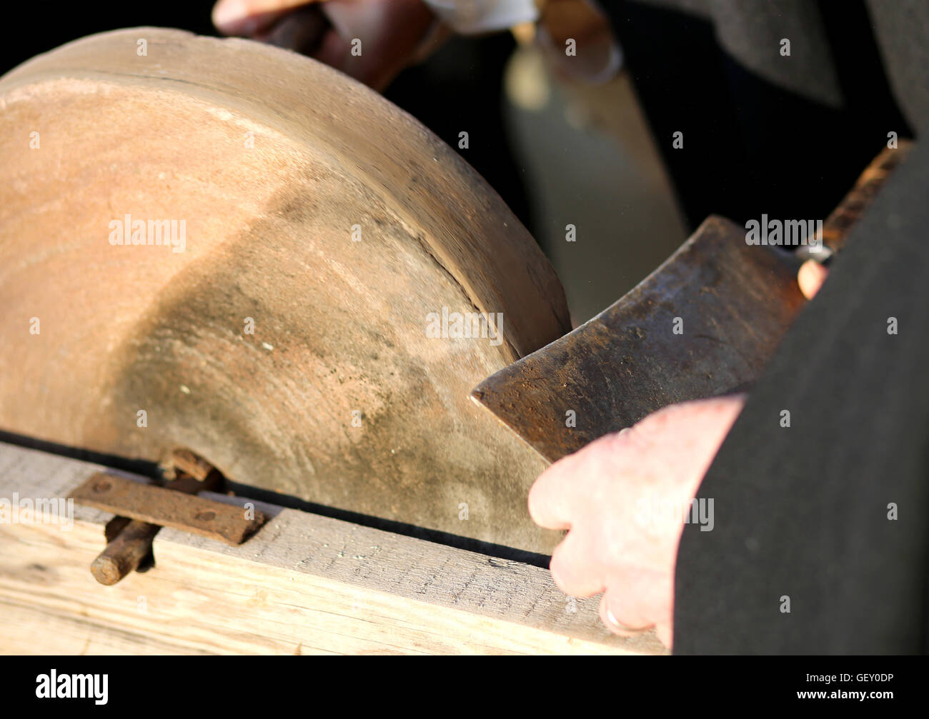 knife sharpener sharpens his knife on the grinding wheel Stock Photo