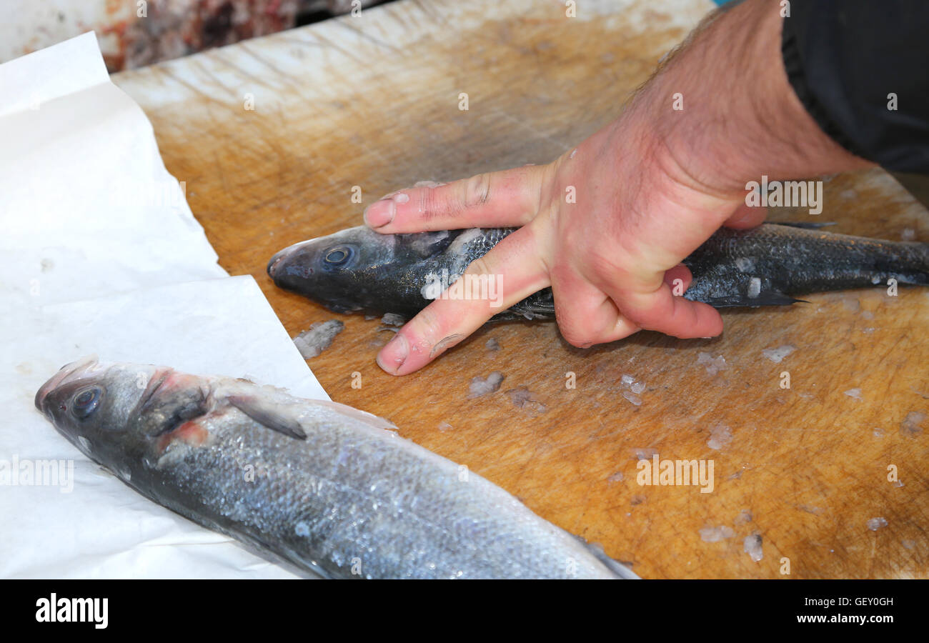 hands the fishmonger at the seafood market during cleaning of freshly