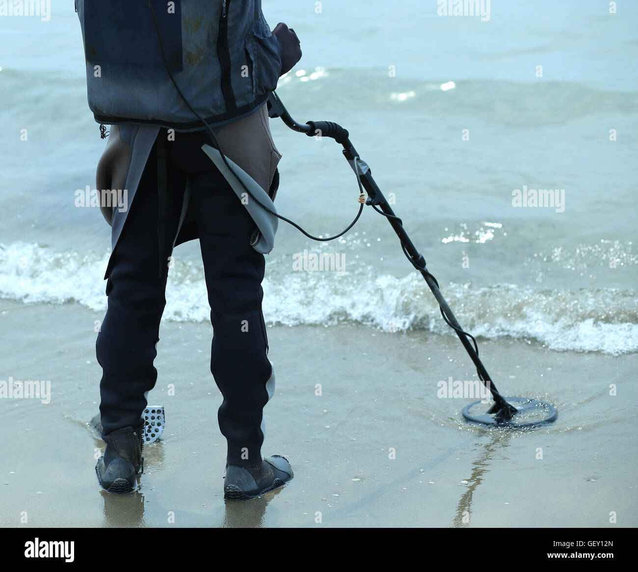 Man with metal detector on the beach to find lost objects under the ...