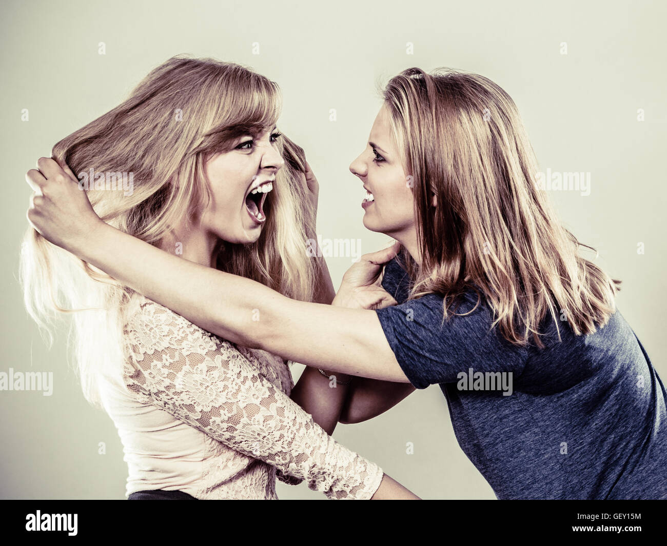 Aggressive mad women fighting each other pulling hair. Two young girls  struggling win catfight. Violence Stock Photo - Alamy