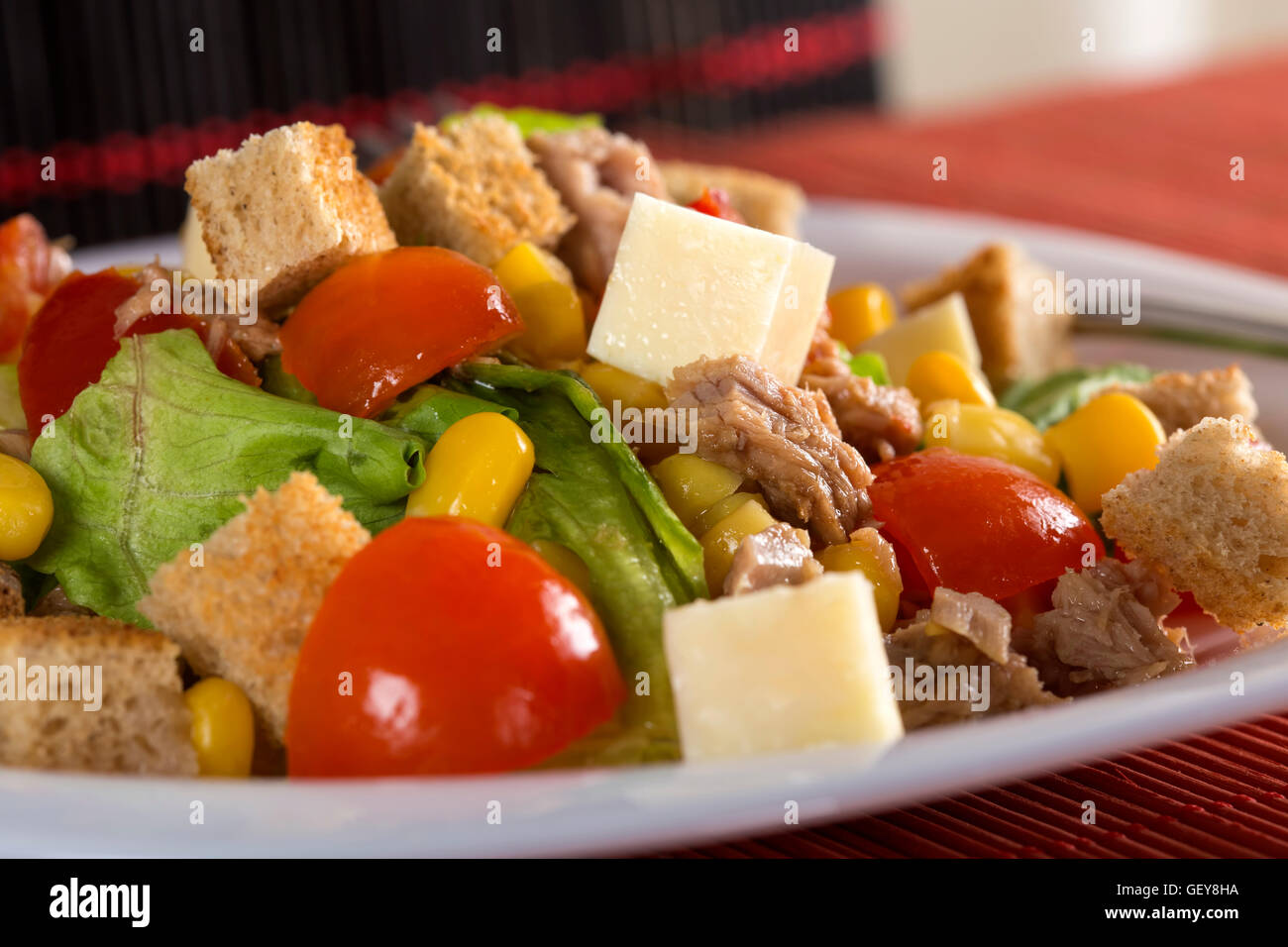 Tuna salad with tomatoes, feta cheese, corn and greens on plate Stock Photo